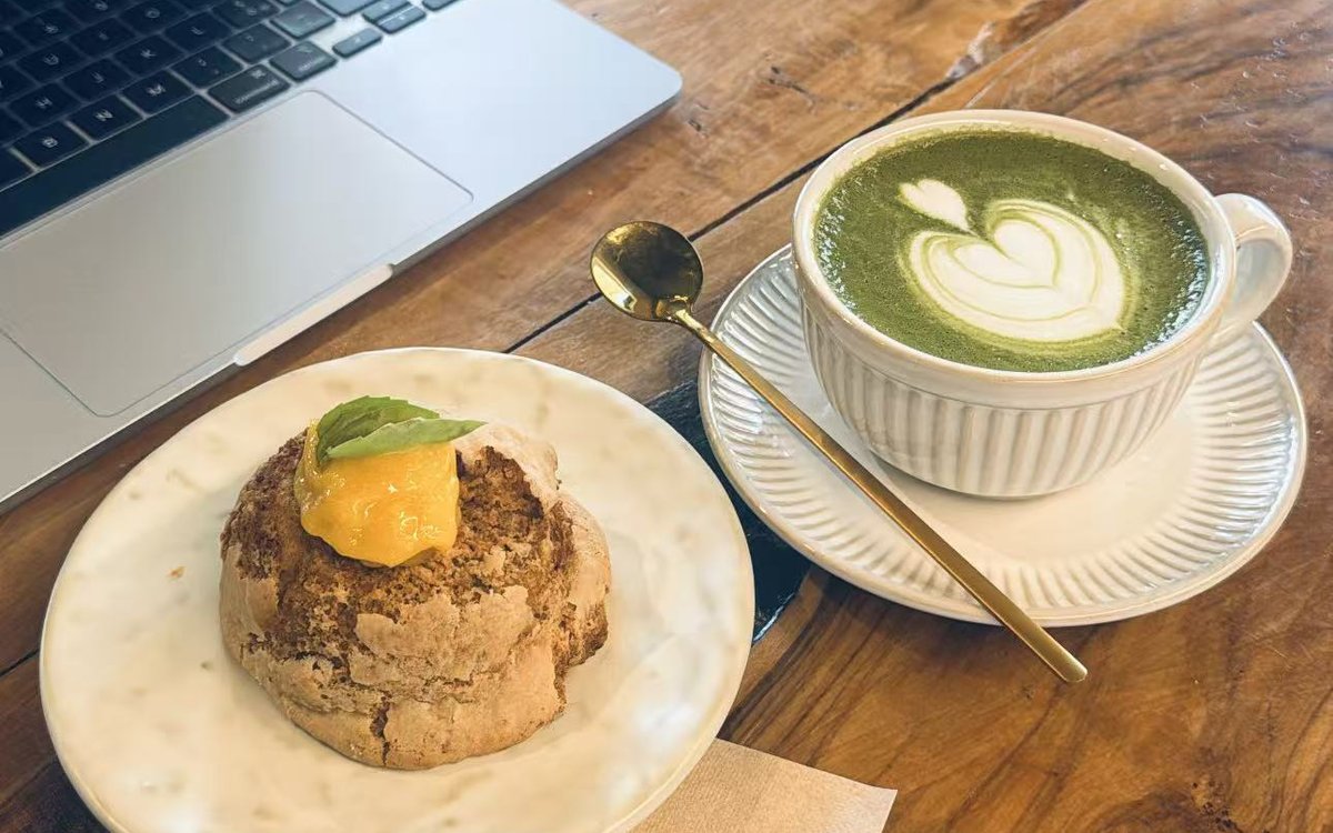 Matcha latte e portatile su un tavolo di FYSA